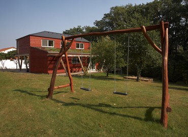 View from the garden to the residential terrace floor, left roofed entrance to the house, right living terrace merging smoothly into the large garden